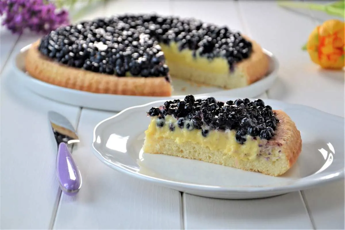porzione di crostata morbida con crema e mirtilli
